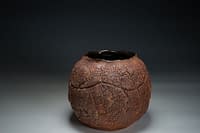 Rich dark moon vase form with heavy earth texture.