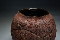 Rich dark moon vase form with heavy earth texture.