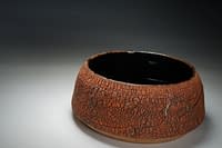 Textured surface bowl with tenmoku glaze