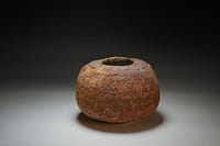 Textured surface vase with dark carbon reduction in the clay